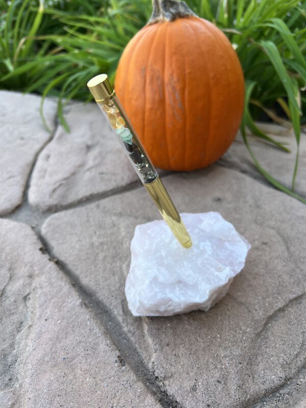 A knife on top of a rock near an orange pumpkin.