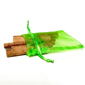 A green bag with some cinnamon sticks in it