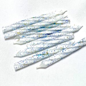 A group of white candles with blue and green speckles.