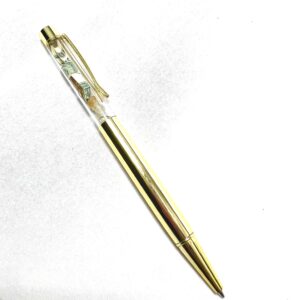 A gold pen with a clear top and white background