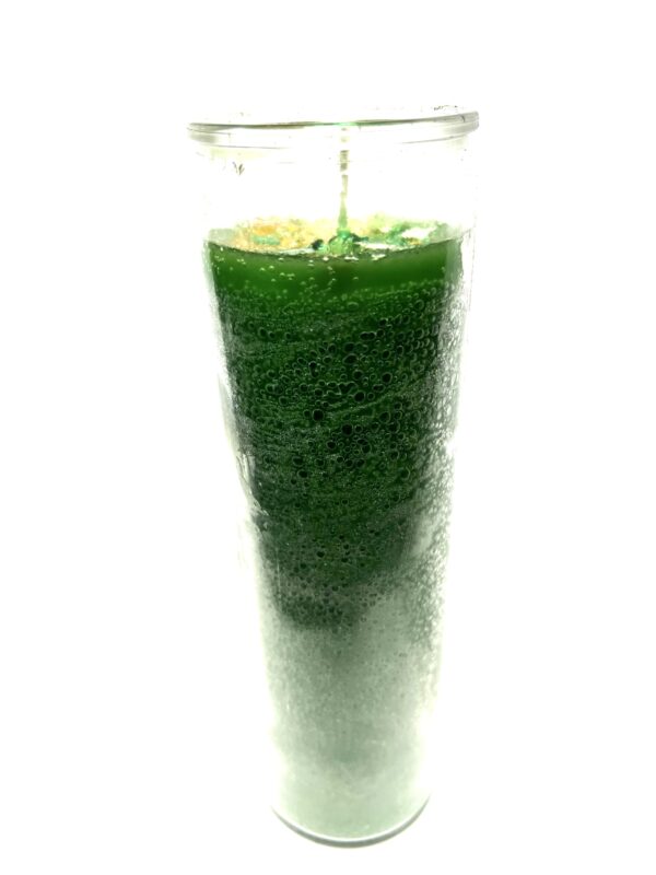 A glass of green liquid with a candle.