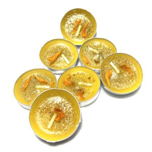 A group of eight tea lights with orange slices.