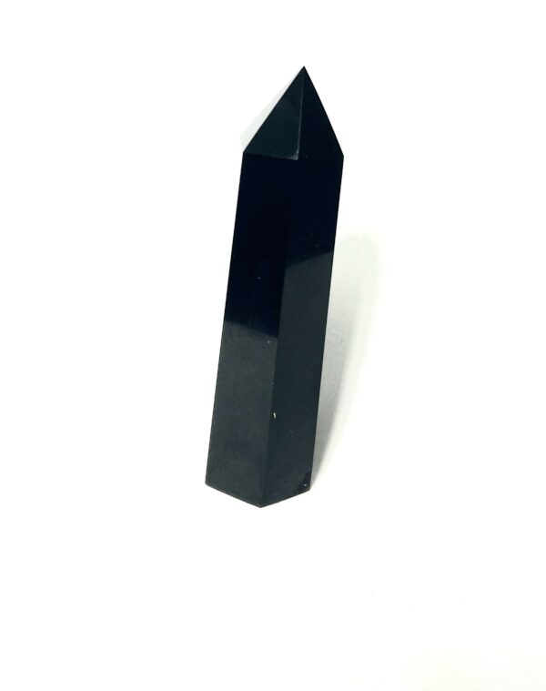 A black stone is standing up on top of the floor.