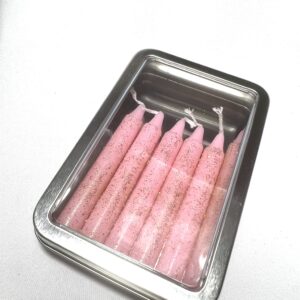 A tin of pink candles in it