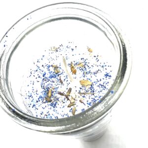 A glass of water with some blue and yellow sprinkles