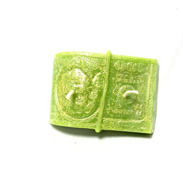 A green piece of candy sitting on top of a table.