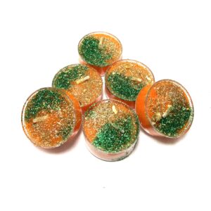 A group of orange candles with green sprinkles.