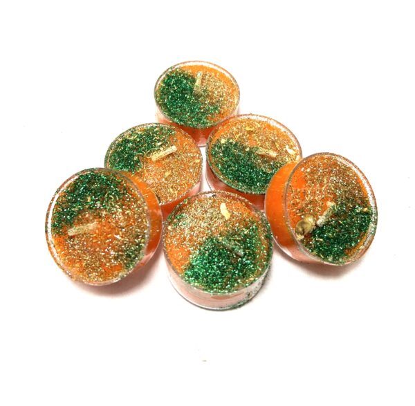 A group of orange candles with green sprinkles.