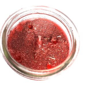 A jar of red liquid on top of a table.