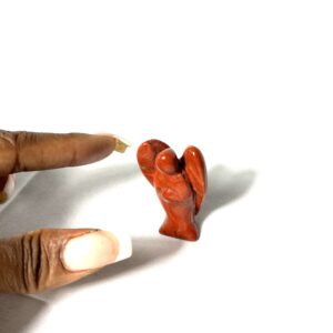 A person 's finger is holding an animal figurine.