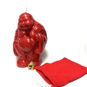 A red candle sitting next to a bag of christmas wrapping.