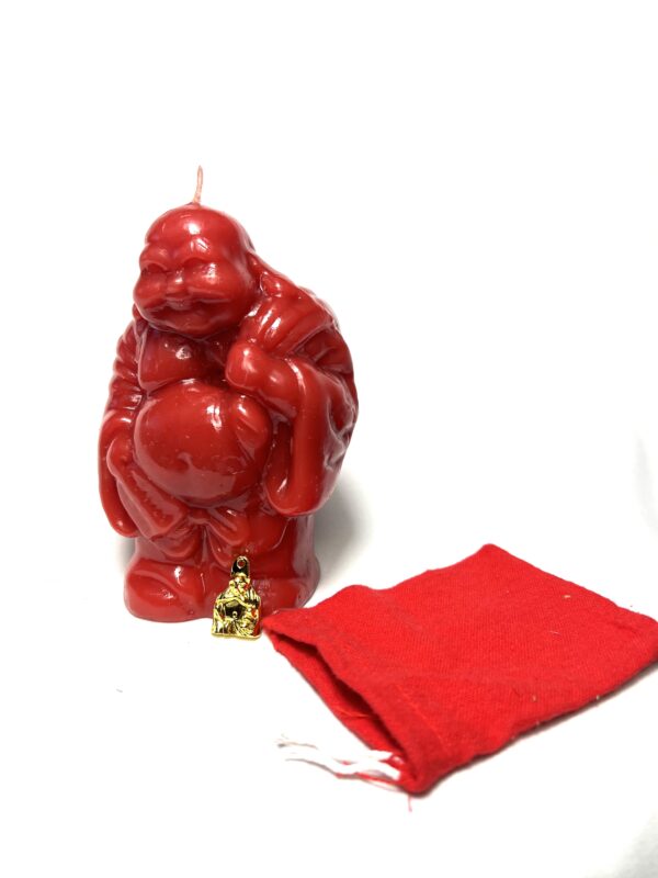 A red candle sitting next to a bag of christmas wrapping.