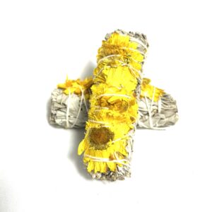 A yellow and silver cross shaped object on top of a white surface.