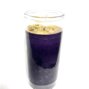 A candle in a glass with purple color.