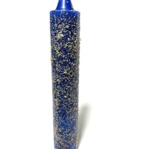 A blue candle with gold flakes on it.