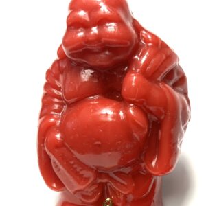 A red gorilla statue sitting on top of a table.