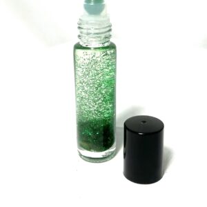 A bottle of green liquid next to a black container.