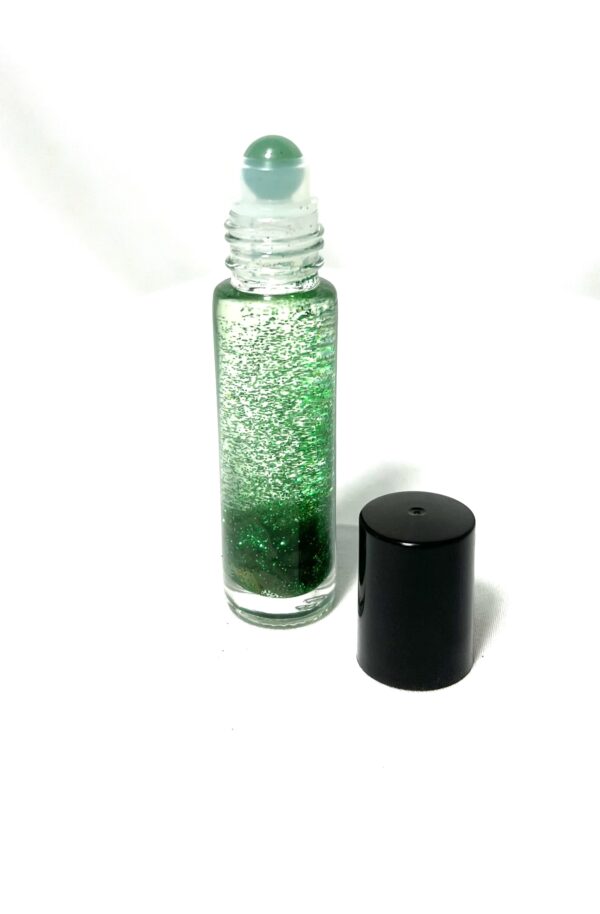 A bottle of green liquid next to a black container.