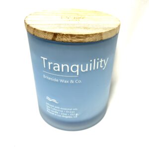 A candle that says tranquility on the front of it.