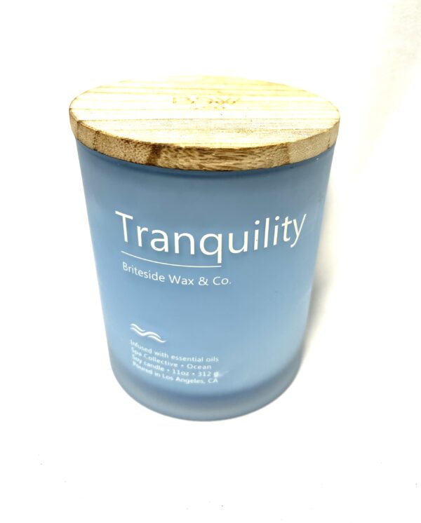 A candle that says tranquility on the front of it.