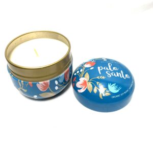 A candle and a tin container with the words " pale smile ".