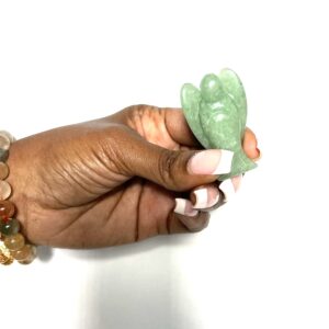 A person holding a green stone in their hand.