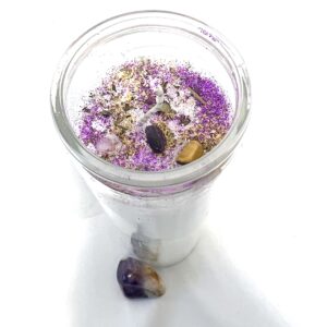 A jar of lavender and white flowers with a small rock in it.