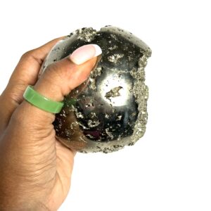 A person holding onto a rock with a green ring around it.