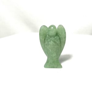 A green stone angel statue sitting on top of a table.