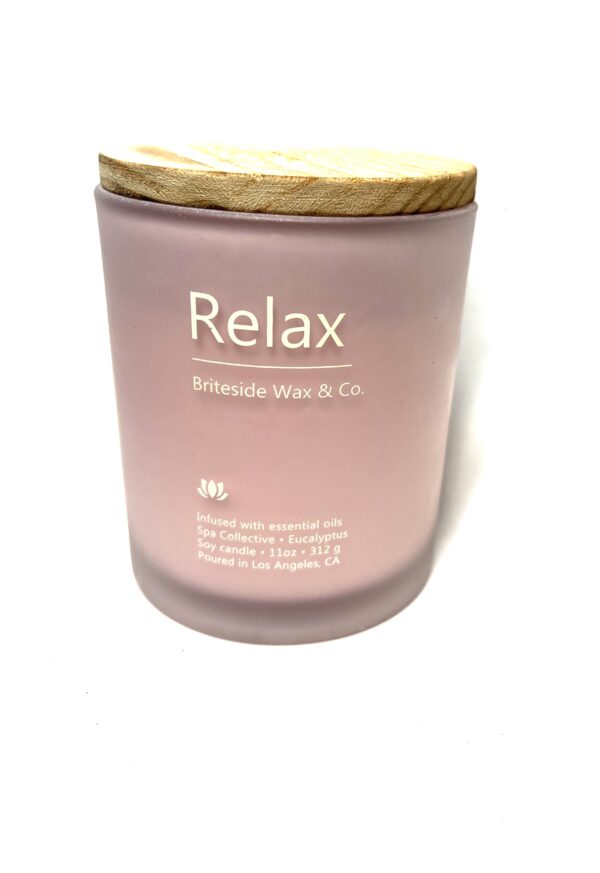 A candle that says relax on it.