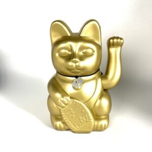 A gold cat with a medal on its neck.