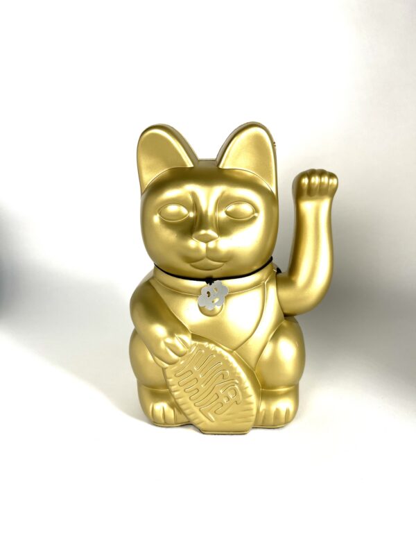 A gold cat with a medal on its neck.