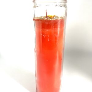 A candle in a glass with orange wax.