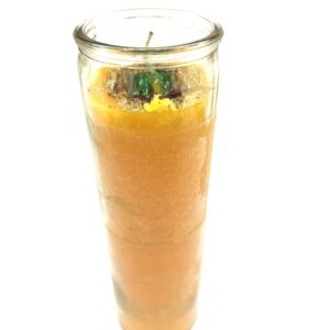 A candle in a glass with some orange and green on it