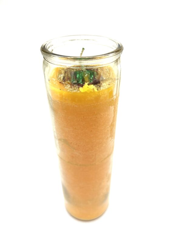 A candle in a glass with some orange and green on it