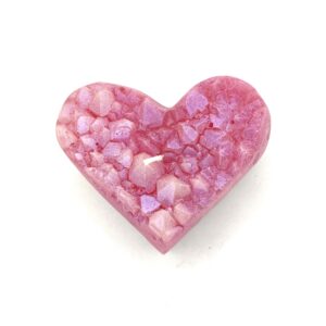 A pink heart shaped candle with pink speckles.