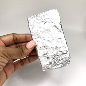 A person holding a piece of tin foil.