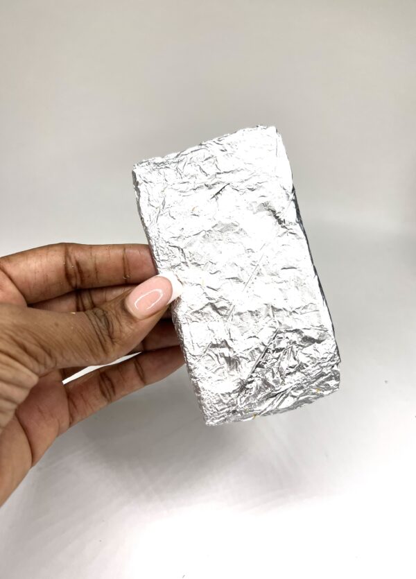 A person holding a piece of tin foil.