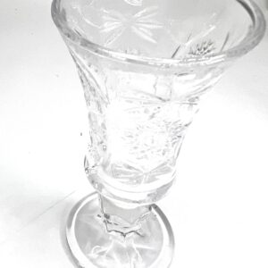 A glass cup with a flower design on it.