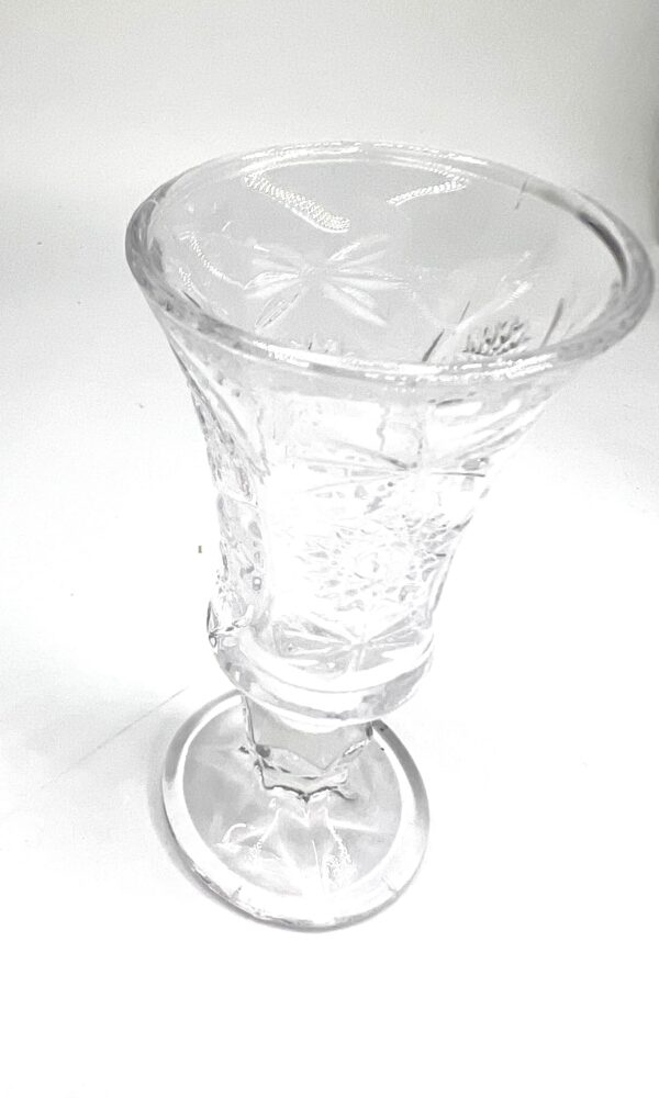 A glass cup with a flower design on it.