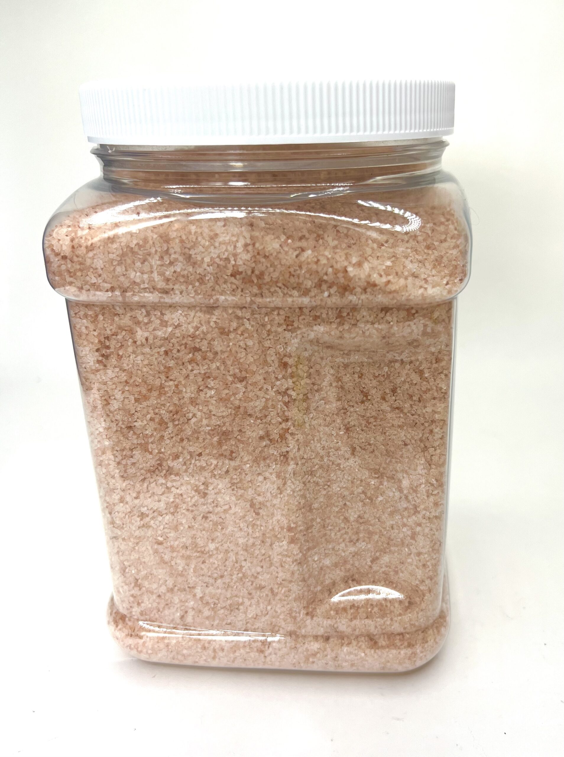 A large container of brown sand with white lid.