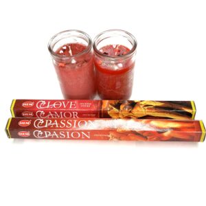 Two candles and a pair of jars with red liquid.