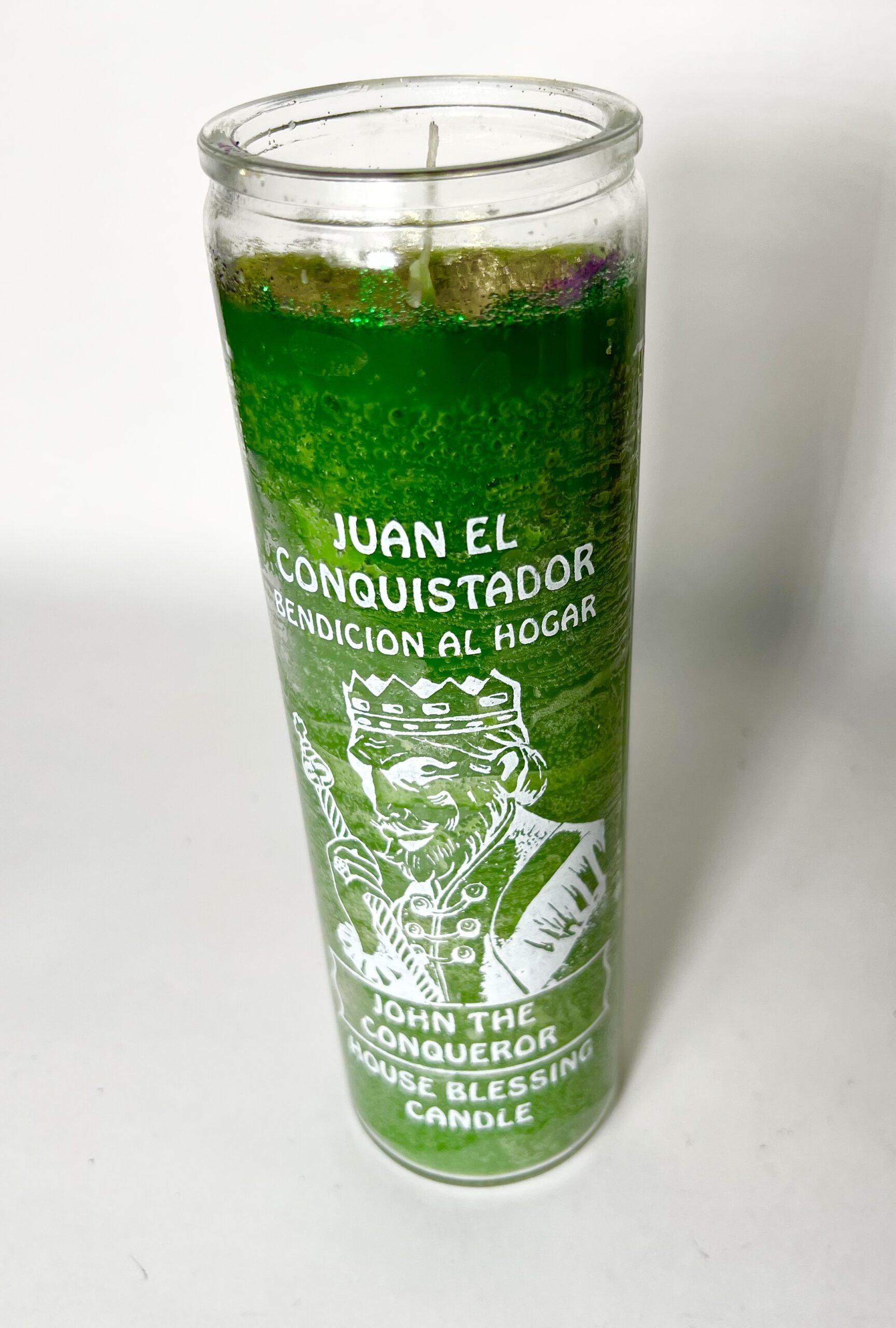 A green candle with the image of juan el conquistador.