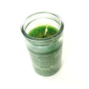 A candle in a jar with green moss on it.