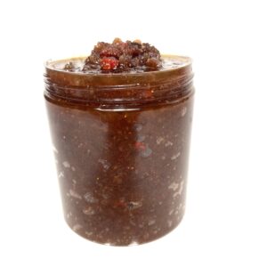 A jar of chocolate spread with nuts on top.