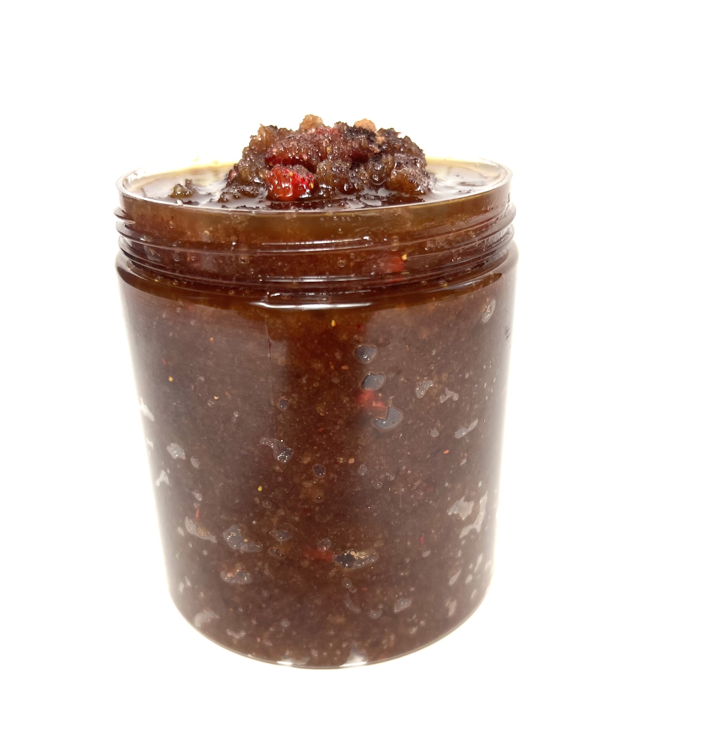 A jar of chocolate spread with nuts on top.