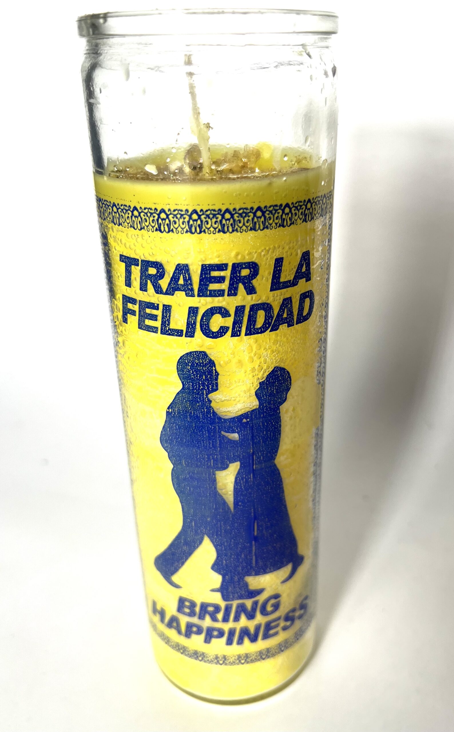 A candle with the words traer la felicidad written on it.