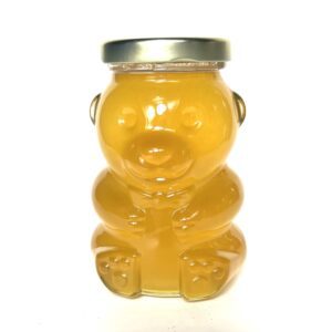 A bear shaped jar of honey with metal lid.