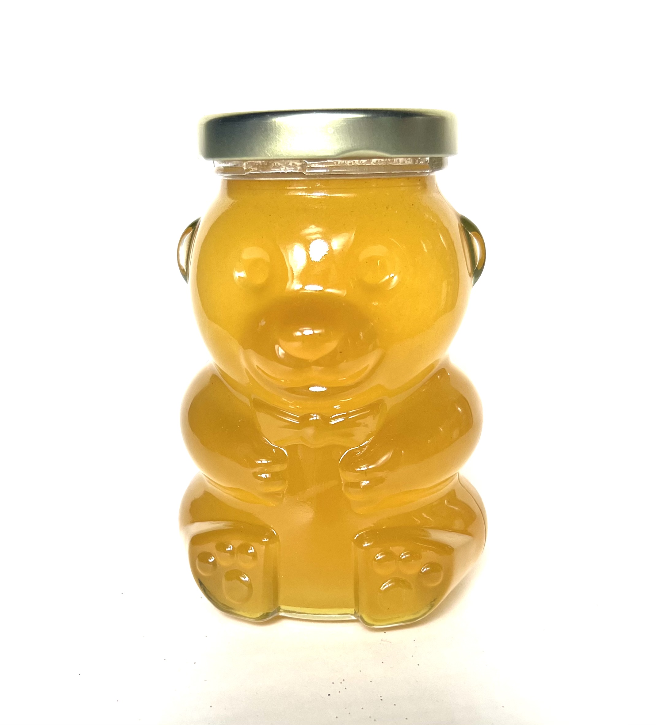 A bear shaped jar of honey with metal lid.