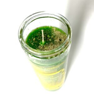 A candle in a glass with green wax.